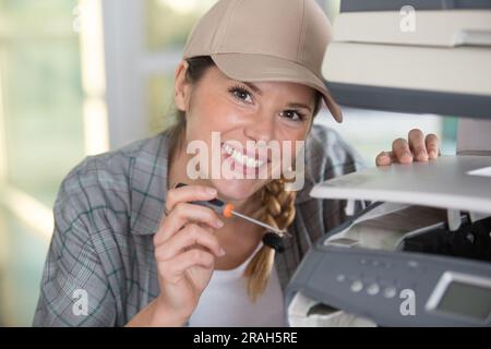a woman fixing a printer Stock Photo