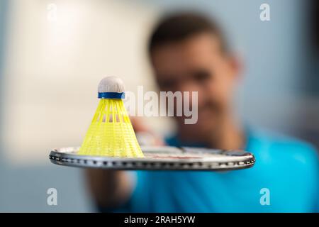 closeup of shuttlecock on racket held by young man Stock Photo