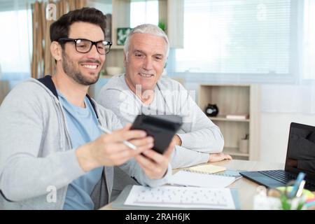 man helping senior neighbor with paperwork Stock Photo
