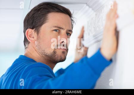 worker installing window curtain rod on the wall Stock Photo