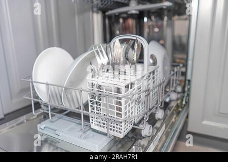 Dirty dishes in dishwasher in the kitchen Stock Photo