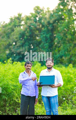Indian farmer holding laptop, smart farming Stock Photo