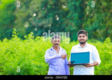 Indian farmer holding laptop, smart farming Stock Photo