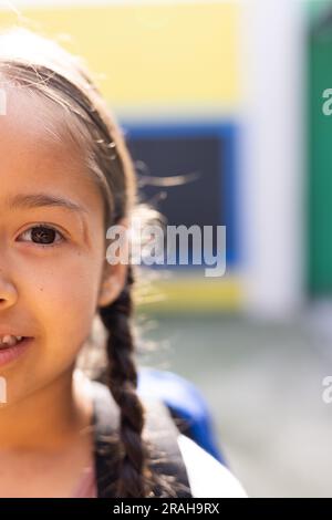Half face portrait of smiling cauasian elementary schoolgirl in school ...