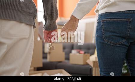 Two men couple holding keys at new home Stock Photo