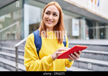 Young caucasian woman student smiling confident using touchpad at university Stock Photo