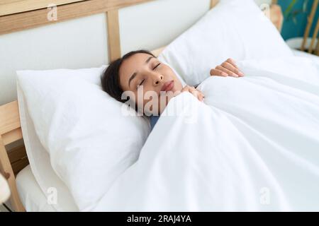Young arab woman lying on bed sleeping at bedroom Stock Photo