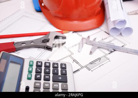 Calculator, helmet and drafting tools on architectural table Stock Photo