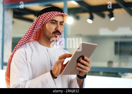 Arab muslim businessman using digital tablet in modern office Stock Photo