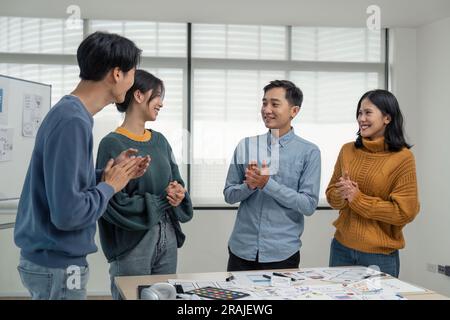 Successful Web developer team. Group of young modern people in casual wear using modern technologies while working web developer Clap your hands to Stock Photo