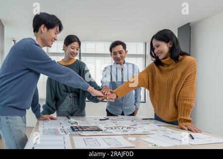 business team of developers or graphic designers putting their hands together at working table in office Stock Photo