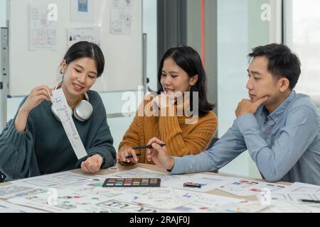 Creative designer choosing color samples for mobile responsive website development with UI/UX. Developing wireframe sketch layout design mockup on Stock Photo