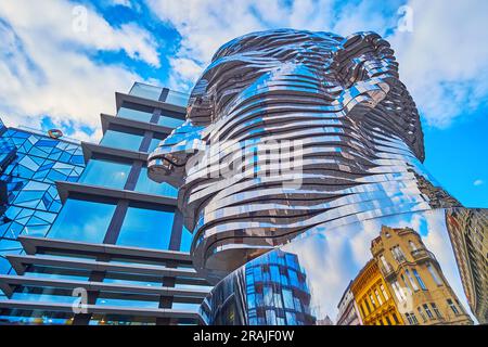 PRAGUE, CZECHIA - MARCH 7, 2022: The moving statue of Franz Kafka against the modern building of the shopping mall, on March 7 in Prague Stock Photo