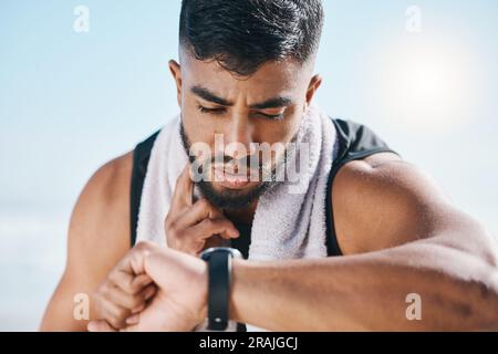 Man, fitness and watch for pulse, heart rate or performance on break after workout, running or training. Fit, active and sporty male person checking Stock Photo