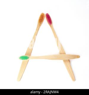 Three multicolored bamboo toothbrushes isolated on a white background. square frame layout. Oral hygiene. Environmentally friendly product. Recyclable Stock Photo