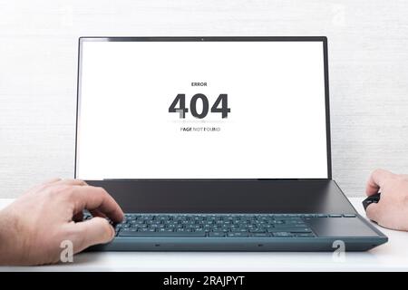 Man working on laptop, 404 error, the message on the screen page not found problem with loading the site Stock Photo