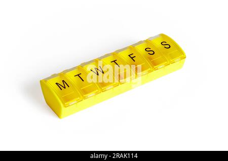A yellow plastic seven-day dosette box, or medical pill dispenser, isolated on a white background, UK Stock Photo