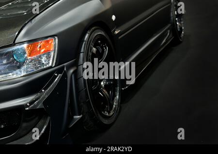 Front headlights of black modify car on black background Stock Photo