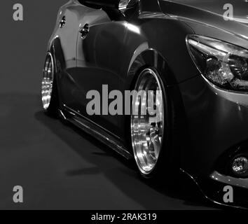 Front headlights of black modify car on black background Stock Photo