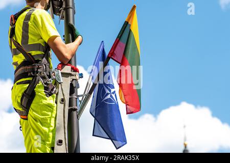 Installing surveillance and security cameras with flags of NATO and of Lithuania before Nato summit 2023 in the centre of Vilnius with tower bell Stock Photo