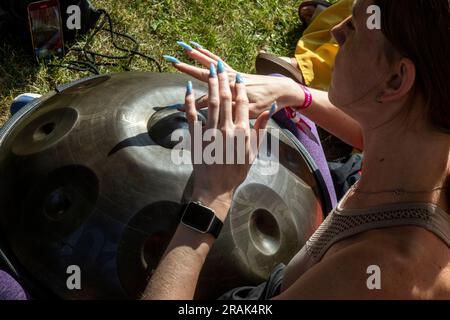 Moscow, Russia. 2nd of July, 2023. A woman learns to play the drum in a park in Moscow, Russia Stock Photo