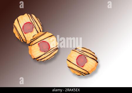 three biscuits on brown background with colour gradient, close up, Stock Photo