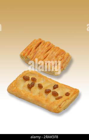 two pieces of apple pie on light brown background with colour gradient, close up, vertical Stock Photo