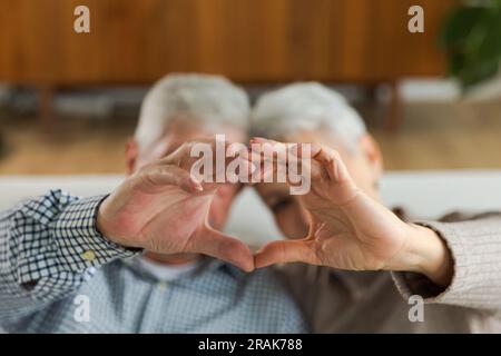 Love heart shape peace. Senior older couple making heart shape with their hands. Adult mature old husband wife showing heart sign. Happy pensioner family. I love you happy valentines day Stock Photo