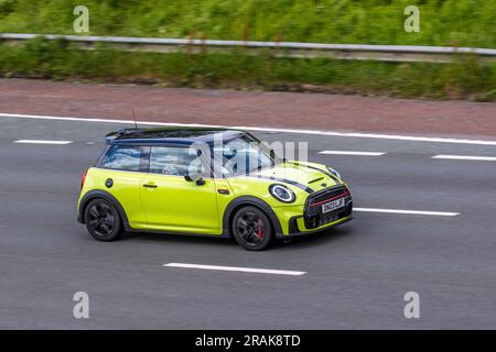 2023 Yellow Mini John Cooper Works Auto, Sport Auto Start/Stop Car Hatchback Petrol 1998 cc, 2.0 litre 4-cylinder petrol engine travelling at speed on the M6 motorway in Greater Manchester, UK Stock Photo