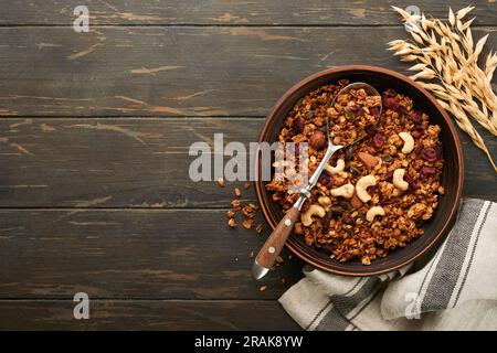 Homemade granola with greek yogurt or milk and cashews, almonds, pumpkin with dried cranberry seeds in old bowl on dark table background. Healthy ener Stock Photo