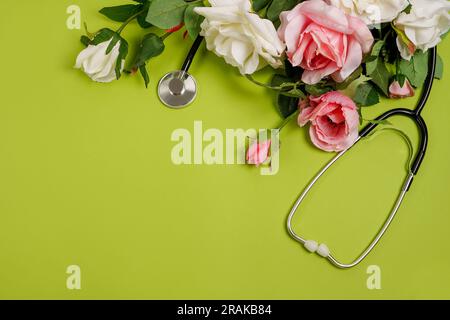 Rose flowers and stethoscope on green background. National Doctor's day. Happy nurse day, greeting card with copy space Stock Photo