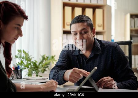 Excited businessman showing coworker product presentation on tablet computer Stock Photo