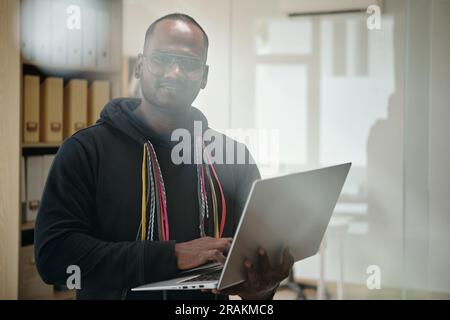 Portrait of senior developer with laptop committing programming code Stock Photo