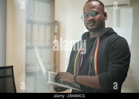 Portrait of software developer in hoodie programming on laptop Stock Photo