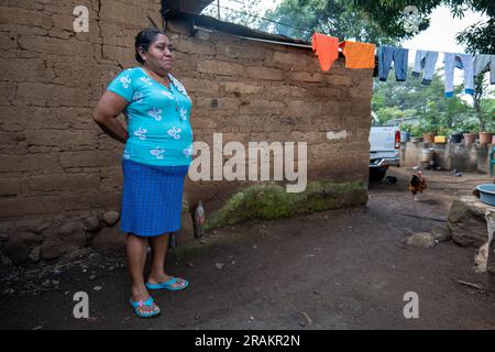 Ahuachapán, El Salvador - November 04 2022: Salvadoran Woman Dressed in Aqua Stands Outside her Home Stock Photo