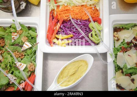 Various fresh salads served on a buffet line, healthy meal option Stock Photo