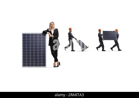 Woman manager standing next to a solar panel and workers carrying panels in the back isolated on white background Stock Photo