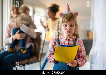 Sad disappointed little girl is jealous because her mom doesn't have time for her Stock Photo