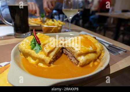 traditional delicious portuguese francesinha in a restaurant in Porto Portugal . Stock Photo