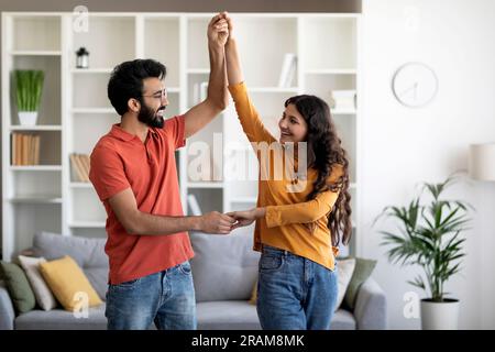 Domestic Romance. Loving Young Indian Spouses Dancing Together At Home Stock Photo
