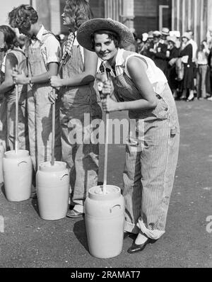 Pomona, California:  c. 1930 Lucille Gates is this year's winner of the American Farm Girl Championships being held at the Los Angeles County Fair. Here she is in action during the butter churning event. Stock Photo