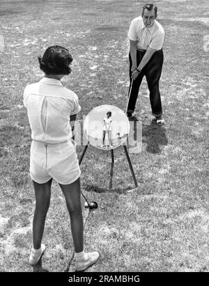 St. Louis, Missouri:  May 1, 1951 Pro golfer Homer Herpel teaches a student with a technique that he developed. He learned to swing left handed so that by using a mirror, his students could compare their swing to his perfect form Stock Photo