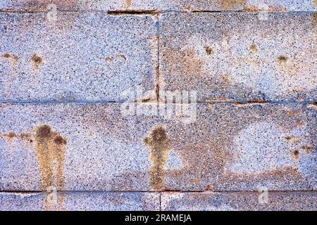 Aged colorful stone blocks, silver gray wall with rusty stains. Stock Photo