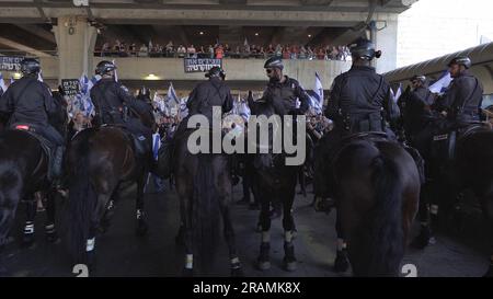 Mounted police wait to disperse anti-government protestors trying to block the entrance to Israel's main international airport during a protest against PM Benjamin Netanyahu and Israel's hard-right government judicial system plan that aims to weaken the country's Supreme Court, at Ben Gurion Airport near Tel Aviv on July 3, 2023 in Lod, Israel. Stock Photo