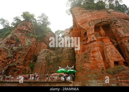 Tourist crowd at the feet of the Leshan Giant Buddha at the confluence of the Min and Dadu rivers in Leshan, China. Stock Photo