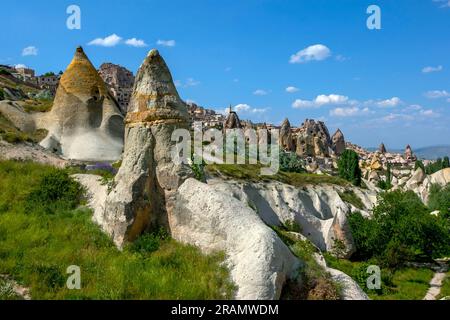 A view from inside Pigeon Valley looking towards the town of Uchisar in the Cappadocia region of Turkiye. Many volcanic rock formations known as fairy Stock Photo