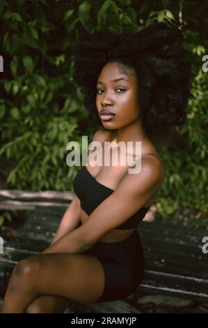 Outdoor portrait Beautiful young African American Black woman with slim  perfect body naked shoulders posing outside, sunny summer day green  foliage. Cosmetology, natural skin care and spa Stock Photo - Alamy