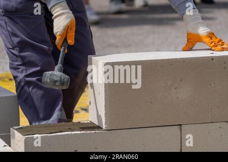 The bricklayer is working. Building a wall of aerated concrete. Stock Photo