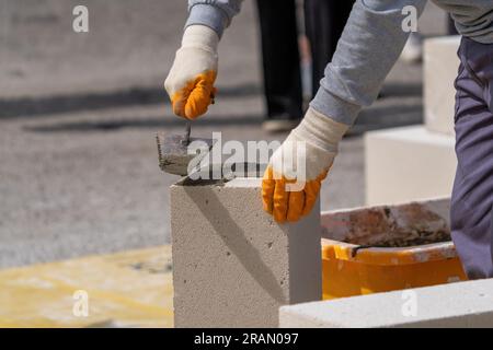 The bricklayer is working. Building a wall of aerated concrete. Stock Photo