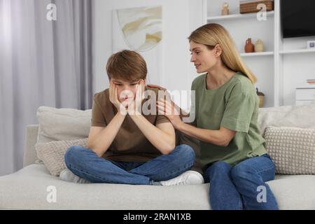 Mother comforting her upset teenage son at home Stock Photo